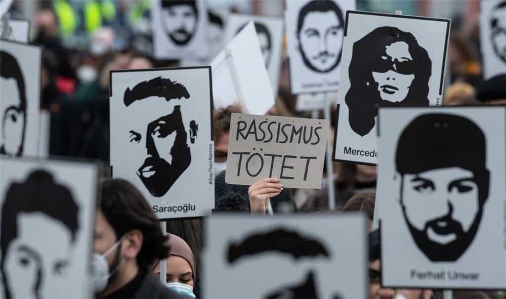 Mit Plakaten und Bildern der Ermordeten erinnern Teilnehmer einer Gedenkveranstaltung an die Opfer des rassistischen Anschlags von Hanau am 19. Februar 2020.