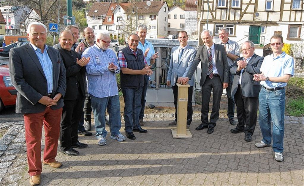 Mit einem symbolischen Knopfdruck eröffnen OB Frank Schneider und Roland Schmid, Geschäftsführer des Diensteanbieters NeckarCom, (beide in der Mitte) das Internet-Zeitalter der Zukunft in Enzberg. Stadträte und Aufsichtsräte der Stadtwerke sowie weitere Zaungäste applaudieren erfreut.Foto: Kollros