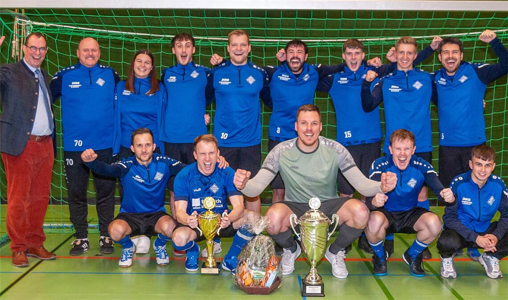 Mit jubelnden Enzbergern endete der Hallen-Stadtpokal 2025. OB Frank Schneider (li.) und Trainer Sascha John (2.v.li) sind heuer nicht mehr in Amt und Würden. Foto: Fotomoment