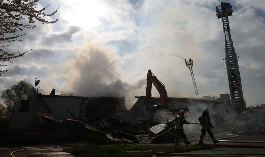 Mit schwerem Gerät arbeitet sich die Feuerwehr zu Glutnestern vor nach einem Brand in einem Club.