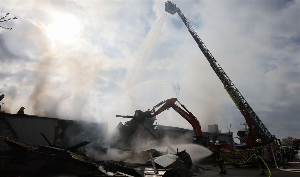 Mit schwerem Gerät arbeitet sich die Feuerwehr zu Glutnestern vor nach einem Brand in einem Club.