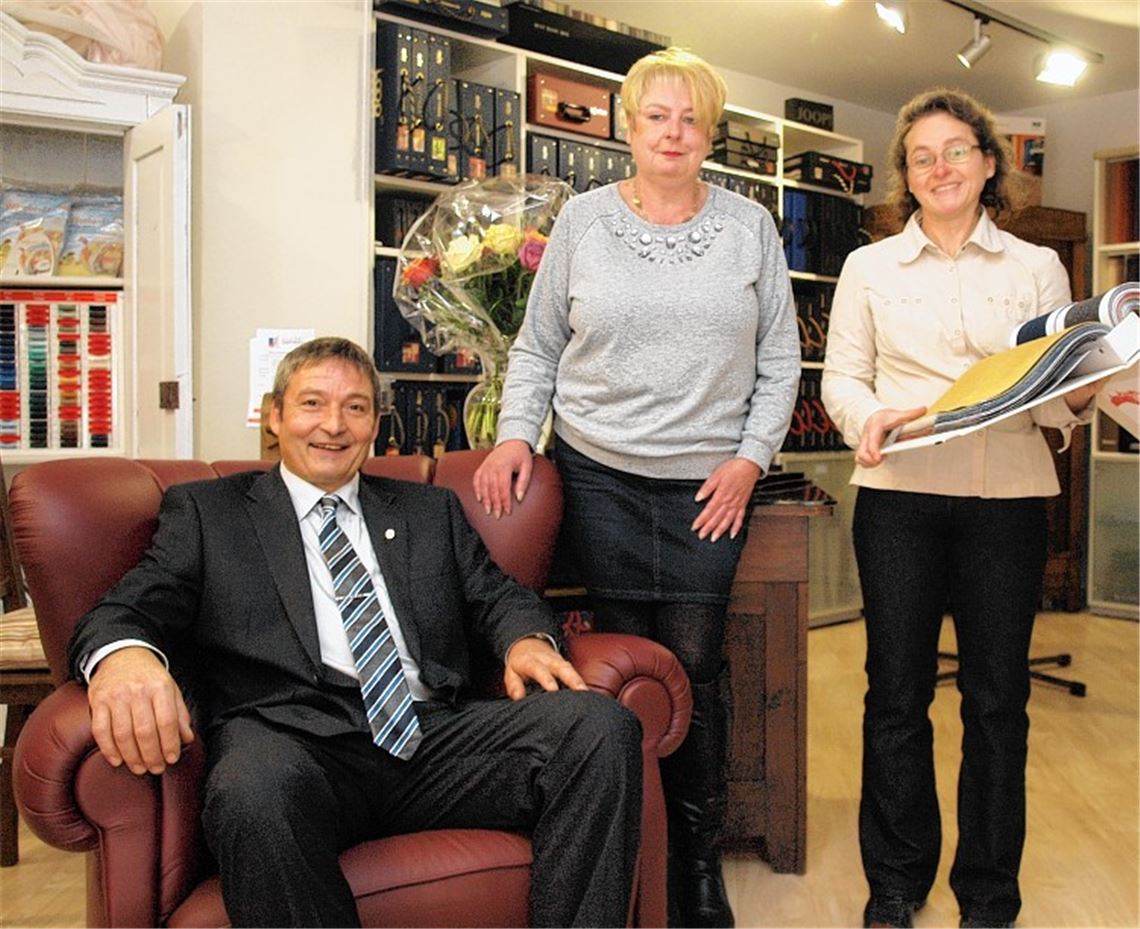 Mit weinrotem Leder hat Frank Jourdan, hier mit Lebensgefährtin Birgit Castan und Mitarbeiterin Martina Regelmann, den Sessel bezogen, den er 1985 zu seiner Meisterprüfung gefertigt hat. Foto: Appich