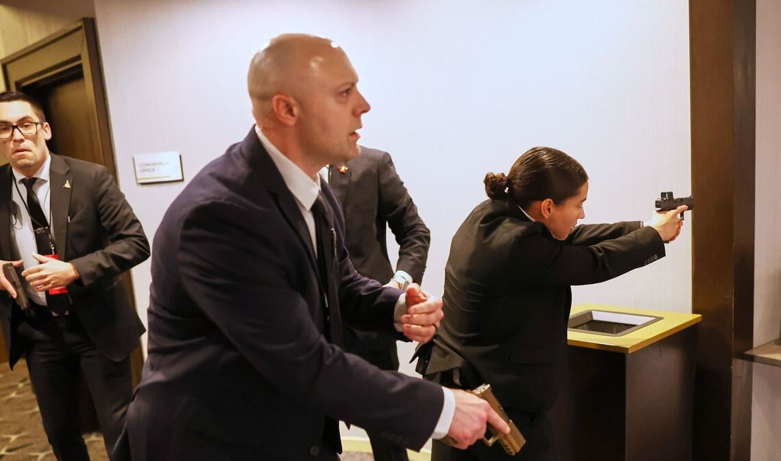 Mitarbeiter des Sicherheitsteams schützen den Präsidenten.