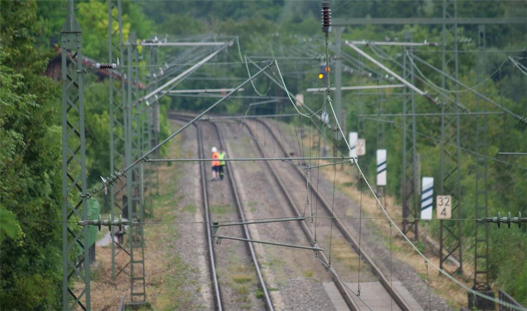 Mitarbeiter gehen den Streckenabschnitt ab, nachdem die Oberleitung gerissen ist. Fotos: Friedrich