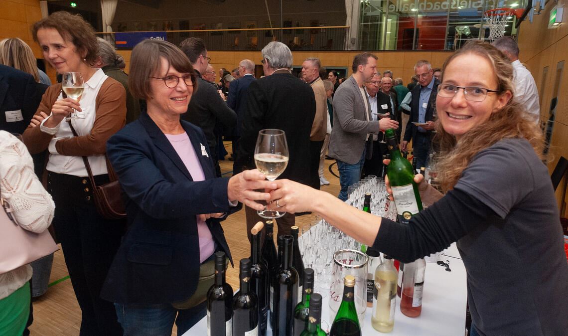 Mitglieder der Winzergenossenschaft schenken ihre Tropfen aus.