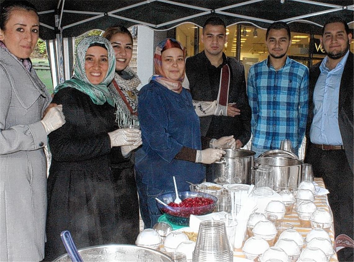Mitglieder des Solidaritätsvereins Mühlacker und des Kulturzentrums für Integration und Bildung verteilen an der Drehscheibe die Süßspeise „Aschûra“. 