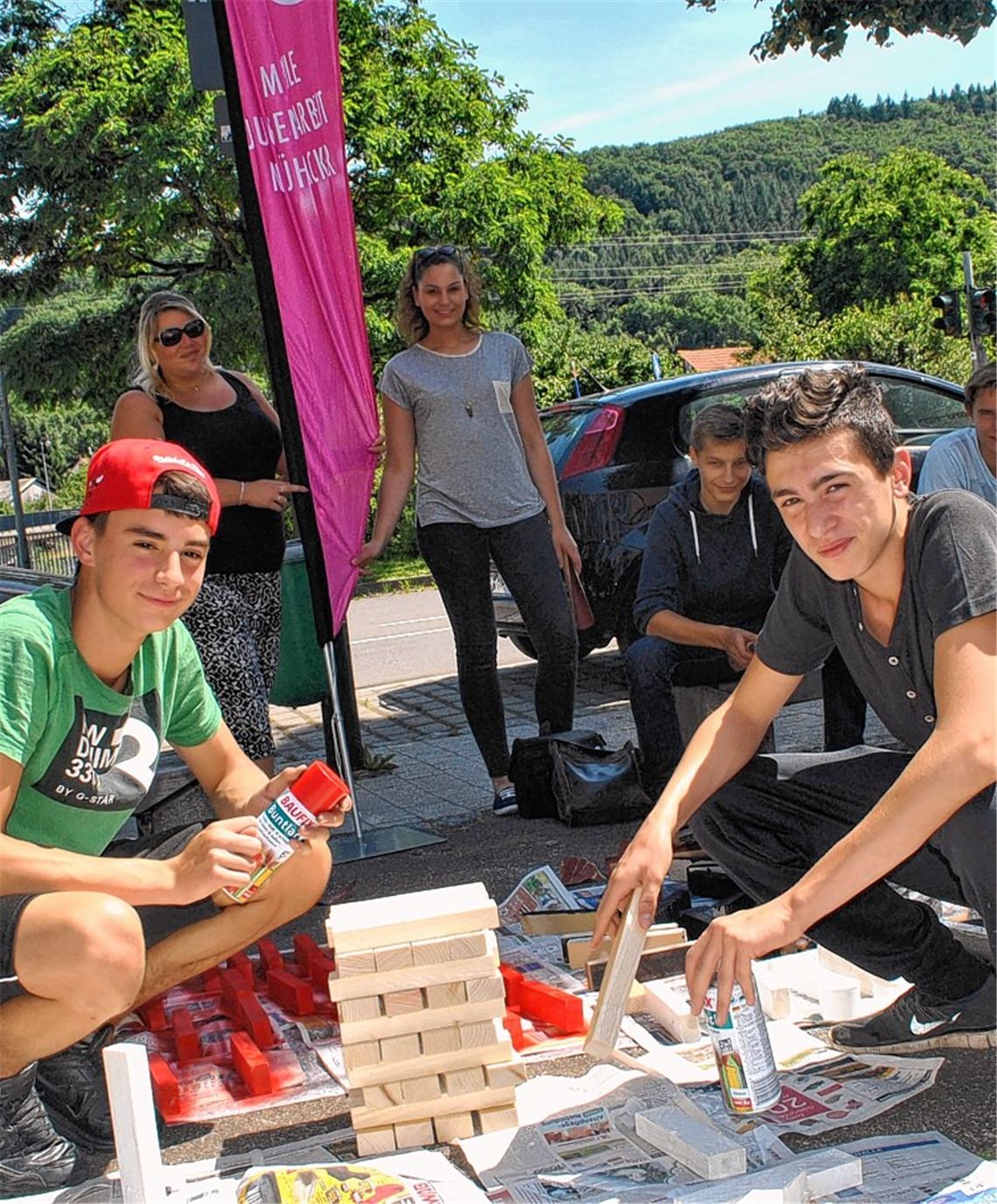 Mobile Jugendarbeit: Gemeinsam mit Jugendlichen werden Holzklötze bunt besprüht, aus denen ein Jenga-Turm gebaut wird. Foto: Stahlfeld