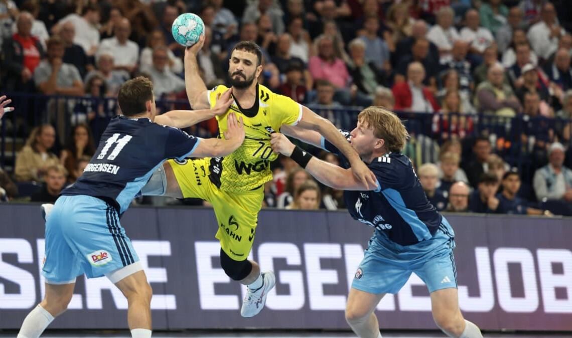 Mohamed Amine Darmoul setzt sich gegen die Hamburger Nicolaj Jörgensen (li.) und Martin Hovde durch&nbsp;– der Rückraumspieler setzte beim 34:34 im Auswärtsspiel wichtige Akzente.