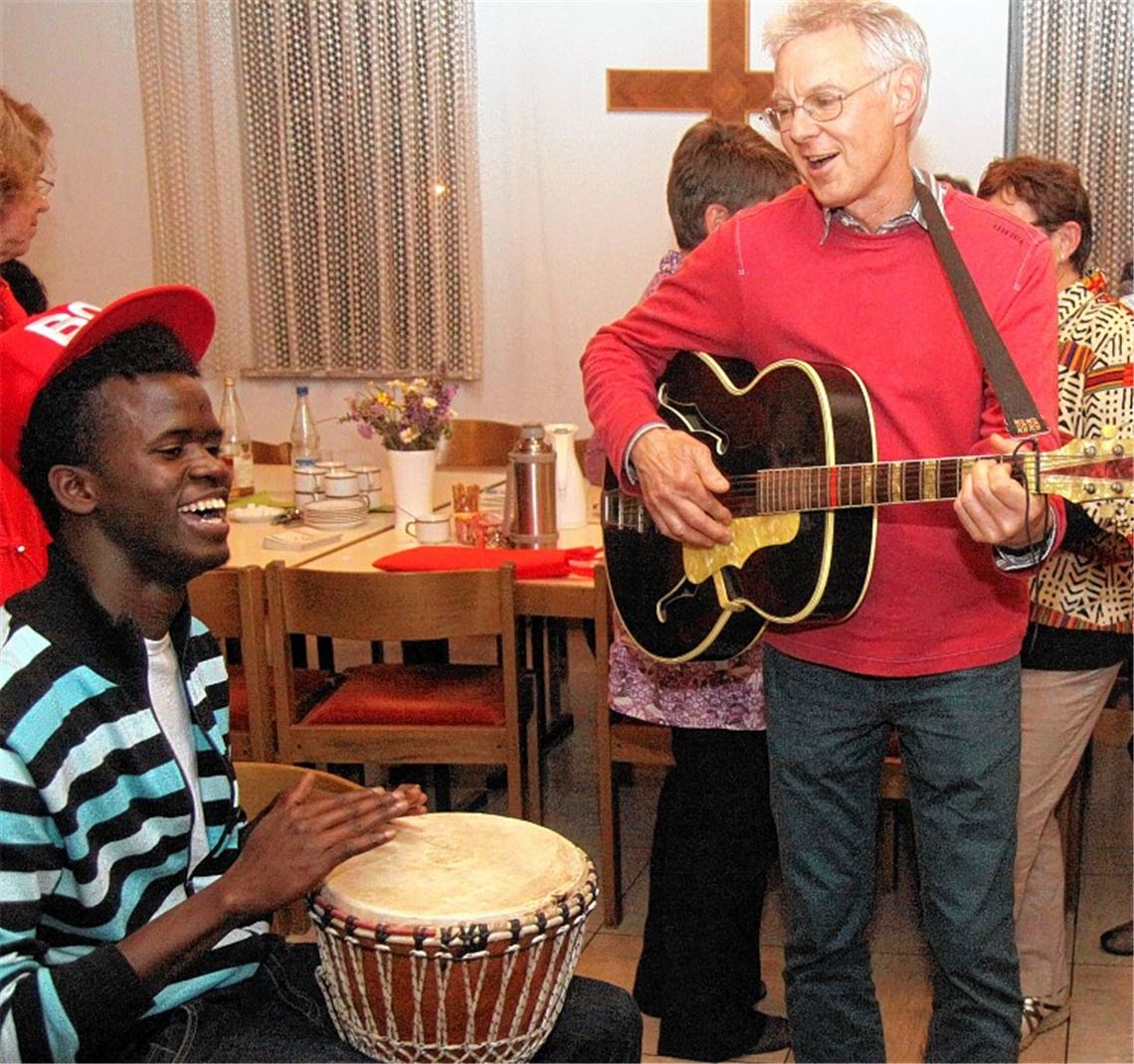 Musik als gemeinsame Sprache: Pfarrer Jürgen Götze und ein Asylbewerber aus Gambia haben viel Spaß miteinander. Foto: Goertz