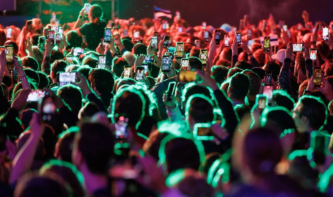 Musikfans feiern im Eurovision Village in Wien vor dem Historischen Rathaus bei einem Konzert.