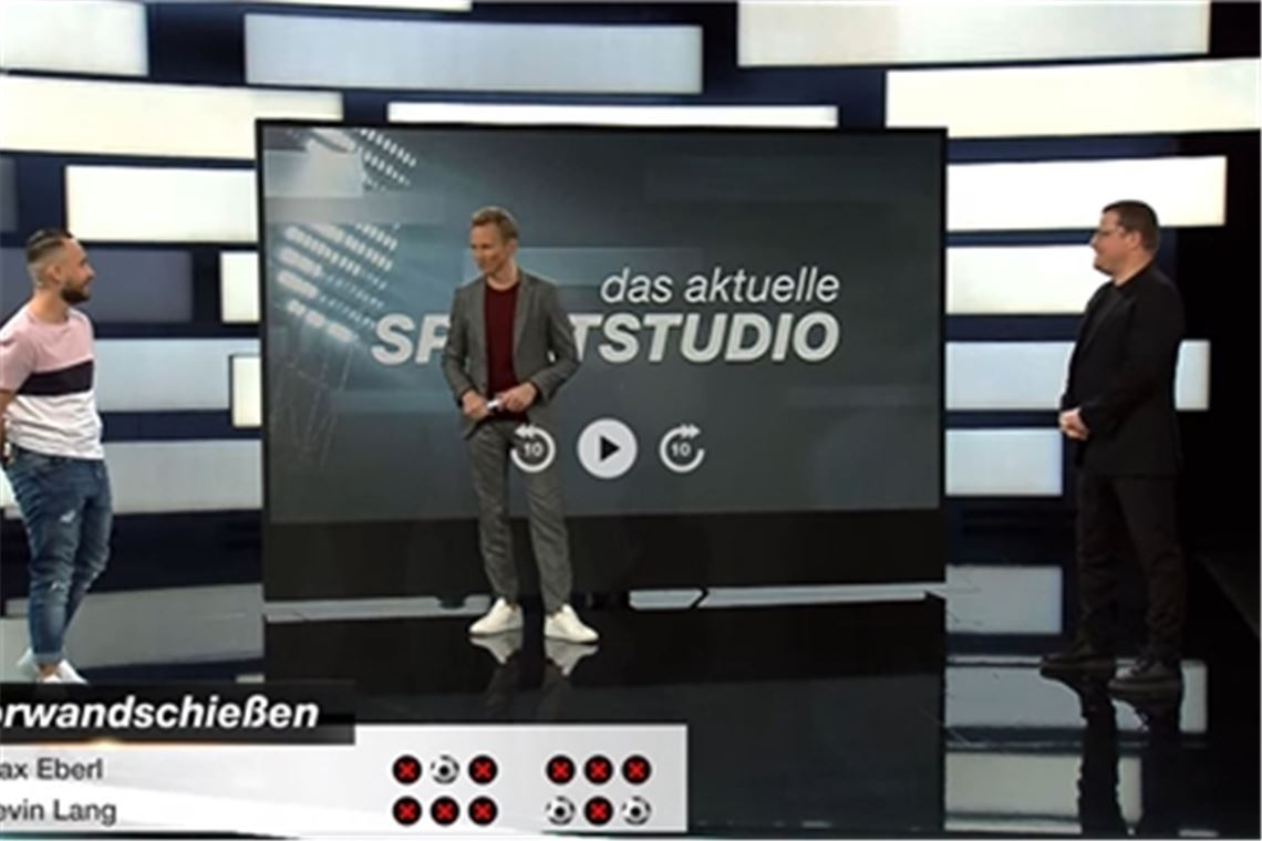Nach dem Sieg an der Torwand: ZDF-Moderator Jochen Breyer Breyer (Mitte) gratuliert Kevin Lang (li.) zum Sieg gegen Max Eberl.Foto: Screenshot
