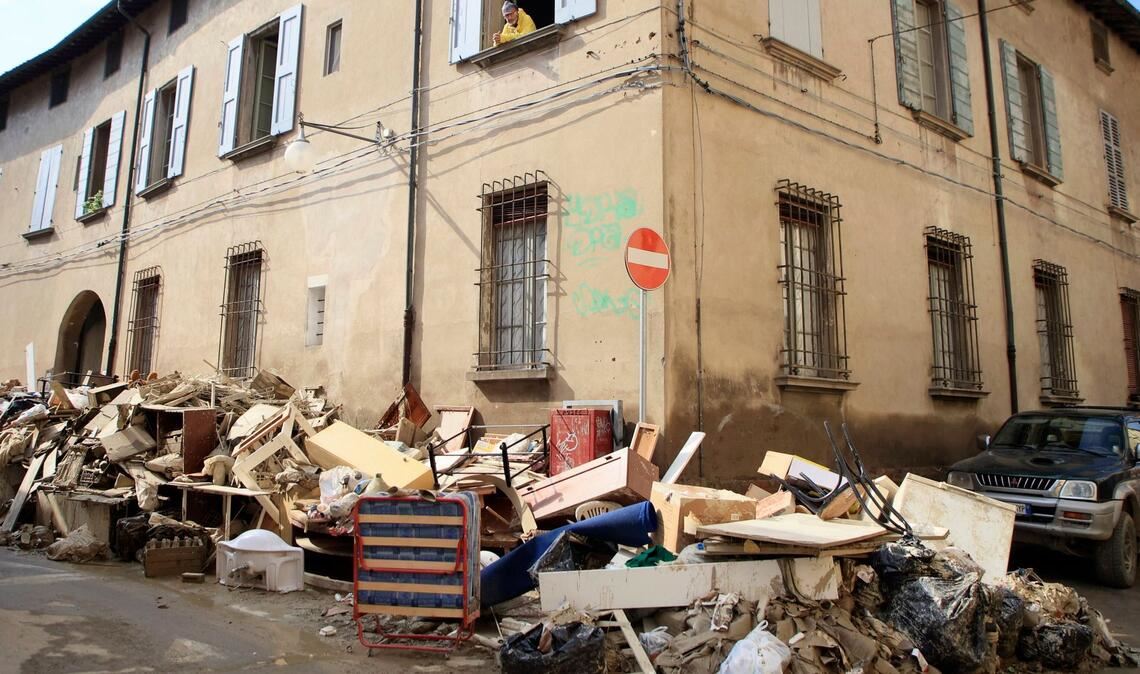 Nach den heftigen Überschwemmungen an der italienischen Adriaküste stehen Aufräumarbeiten an. In Faenza schaut ein Mann aus dem Fenster und sieht Berge voller Haushaltsgegenstände.