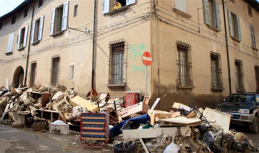 Nach den heftigen Überschwemmungen an der italienischen Adriaküste stehen Aufräumarbeiten an. In Faenza schaut ein Mann aus dem Fenster und sieht Berge voller Haushaltsgegenstände.