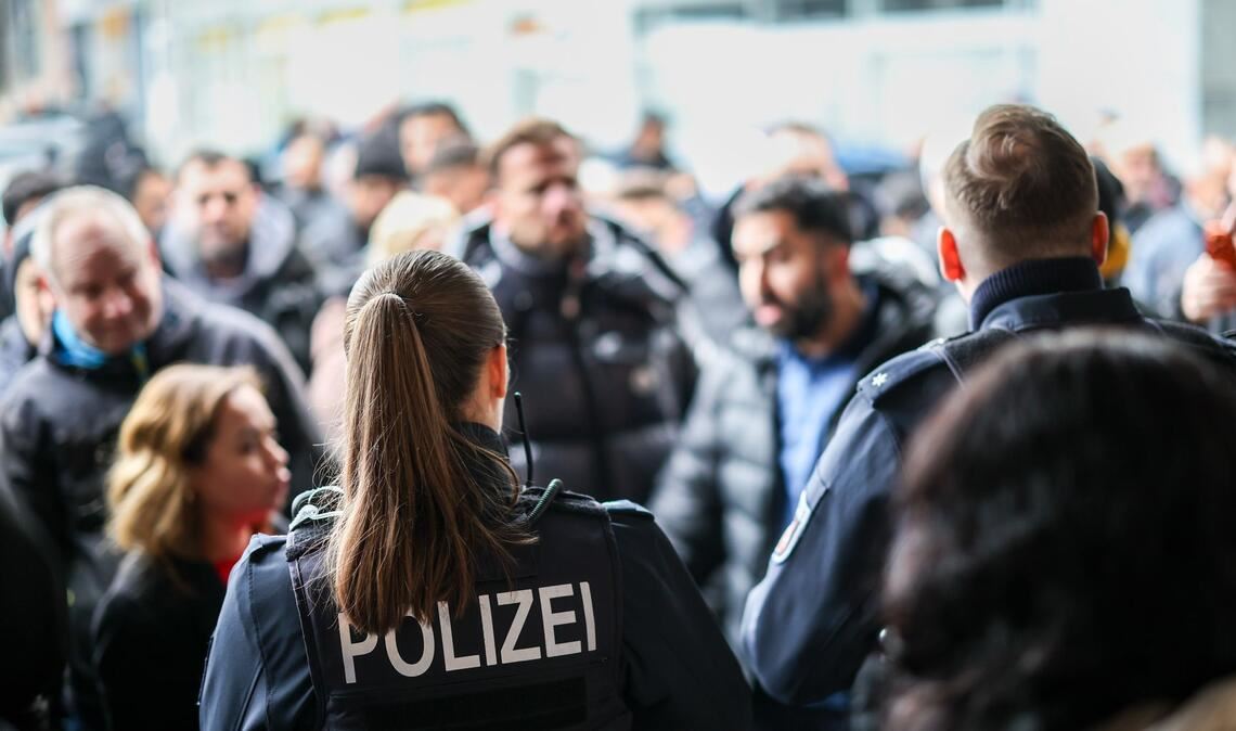 Nach der Räumung des Vorraums der Sparkassenfiliale sichern Polizeibeamte den Bereich vor der Sparkasse.