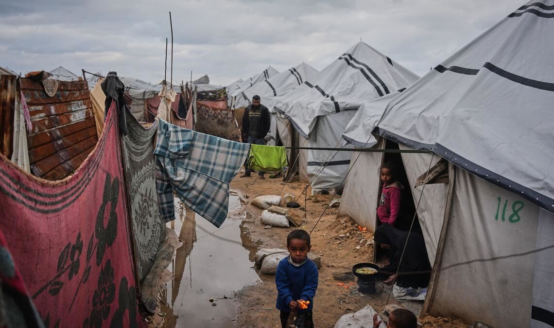 Nanaa Abu Jari kocht in Nuseirat im zentralen Gazastreifen vor ihrem Zelt, das von Regenwasser überflutet wurde..