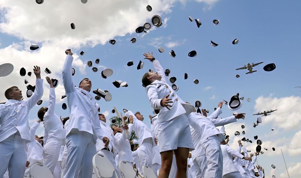 Neu ernannte Fähnriche werfen ihre Mützen zum Abschluss der Feierlichkeiten an der United States Coast Guard Academy in New London in den USA.