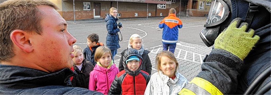 Neugierige Blicke: Gruppenleiter Tobias Bühler (li.) erklärt den Schülern anschaulich, was eine Schutzmaske ist.