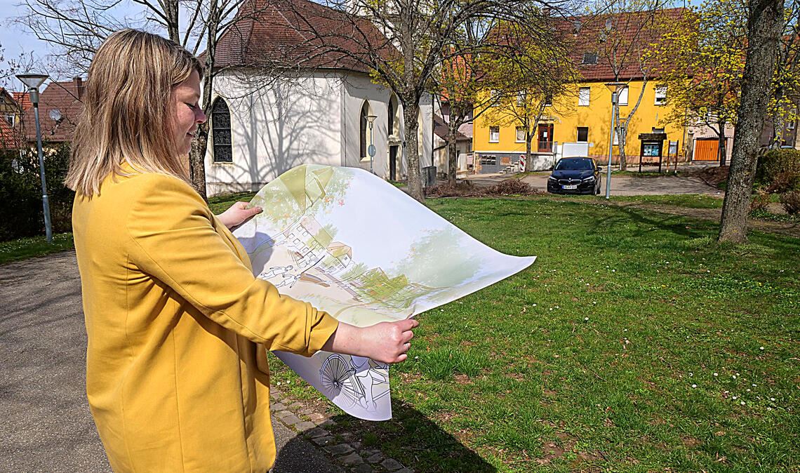 Noch existiert die neue Ortsmitte nur auf den Plänen, Bürgermeisterin Antonia Walch freut sich aber schon darauf, dass der Platz bei der Kirche zu einer Begegnungsstätte werden kann. Foto: Friedrich
