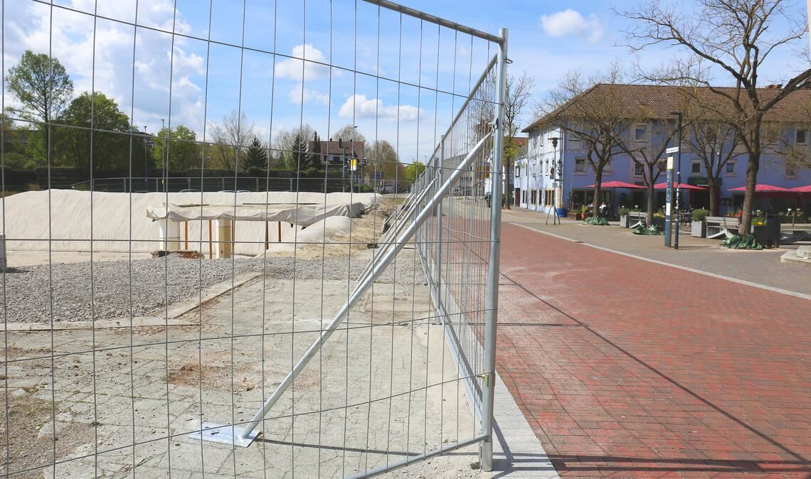 Noch präsentiert sich der Bauzaun ums Loch kahl und wenig ansehnlich. Foto: Schüller