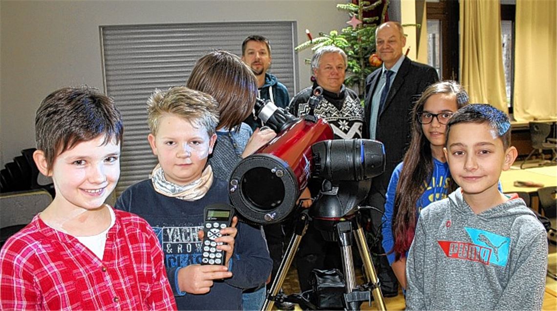 Noch schauen die Astronomie AG-Schüler nur nach den Sternen im Tannenbaum. Bald werden sie mit dem neuen Teleskop den Nachthimmel entdecken. Der Vorsitzende des THG-Fördervereins, Ralf Engelhardt (li.), und THG-Schulleiter Thomas Mühlbayer (re.) beschenken damit die Arbeitsgemeinschaft und ihren Leiter Klaus Gerlinger (Mi.).