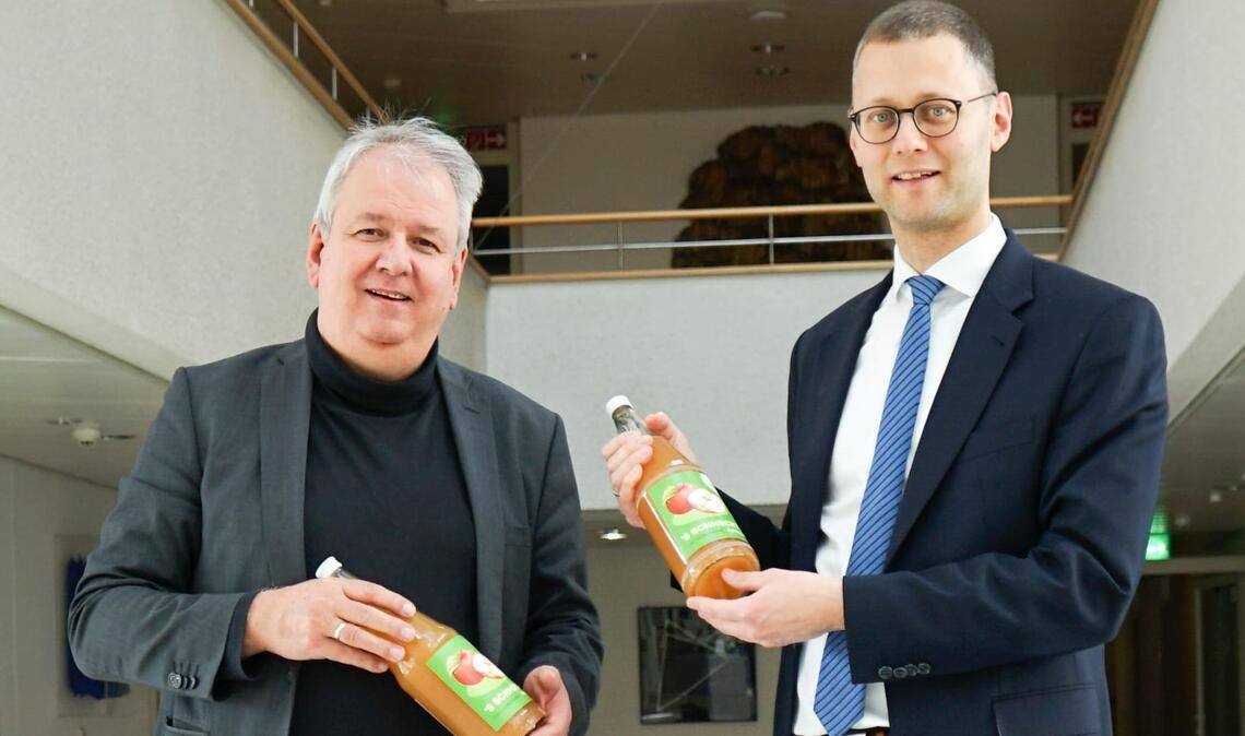 Norbert Bogner (li.) hat Holger Nickel einen Kasten Apfelsaft mitgebracht. Foto: ml/Zimmer