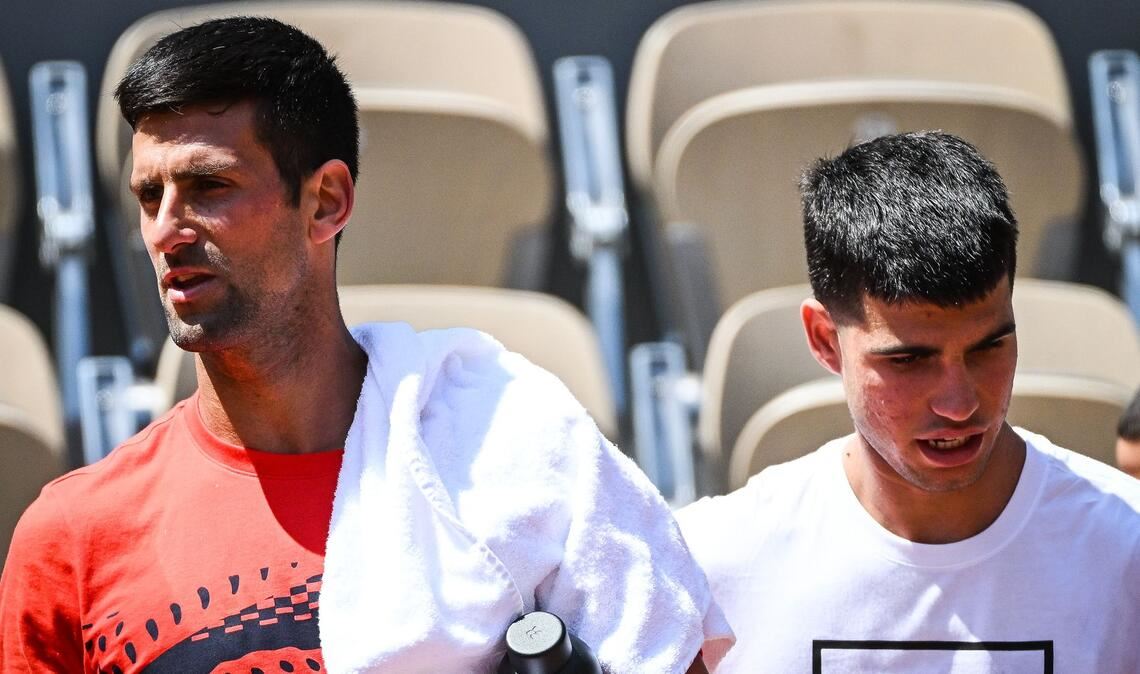 Novak Djokovic (l) aus Serbien und Carlos Alcaraz aus Spanien gehen nebeneinander während einer Trainingseinheit für die French Open 2023.