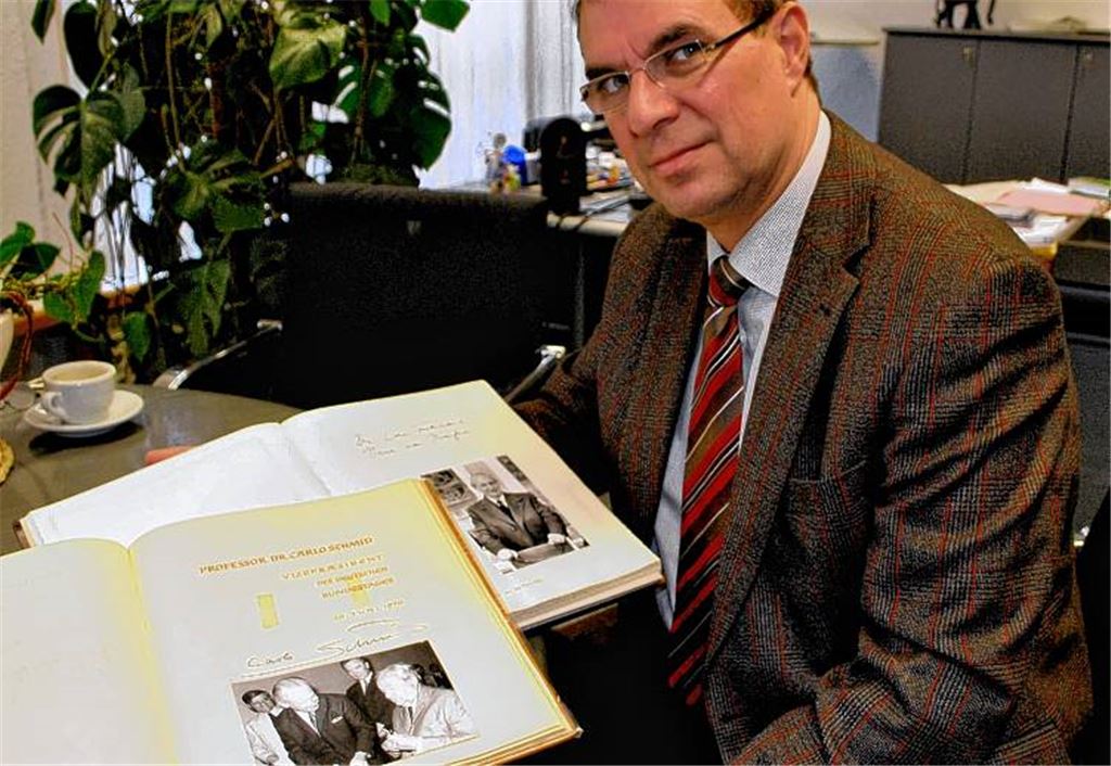 OB Frank Schneider blättert zurück in die Zeiten, als Fotos meist noch schwarz-weiß waren: Mit Professor Carlo Schmid trug sich einer der „Väter der Verfassung“ ins Goldene Buch der Stadt ein.