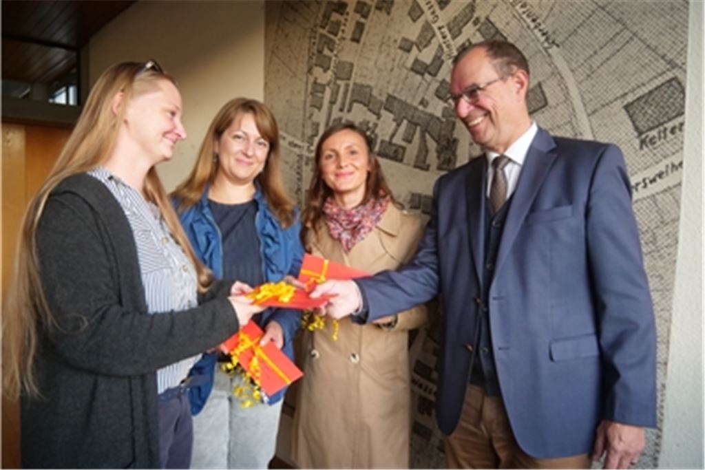 OB Frank Schneider (re.) dankt Jana Geiger, Olga Borger und Nadia Suflea (v.li.) stellvertretend für alle Helfer, die sich für die Geflüchteten engagiert haben. Foto: Friedrich