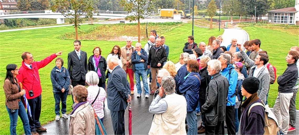 OB Schneider (in roter Jacke) zeigt den Besuchern das Gartenschaugelände.