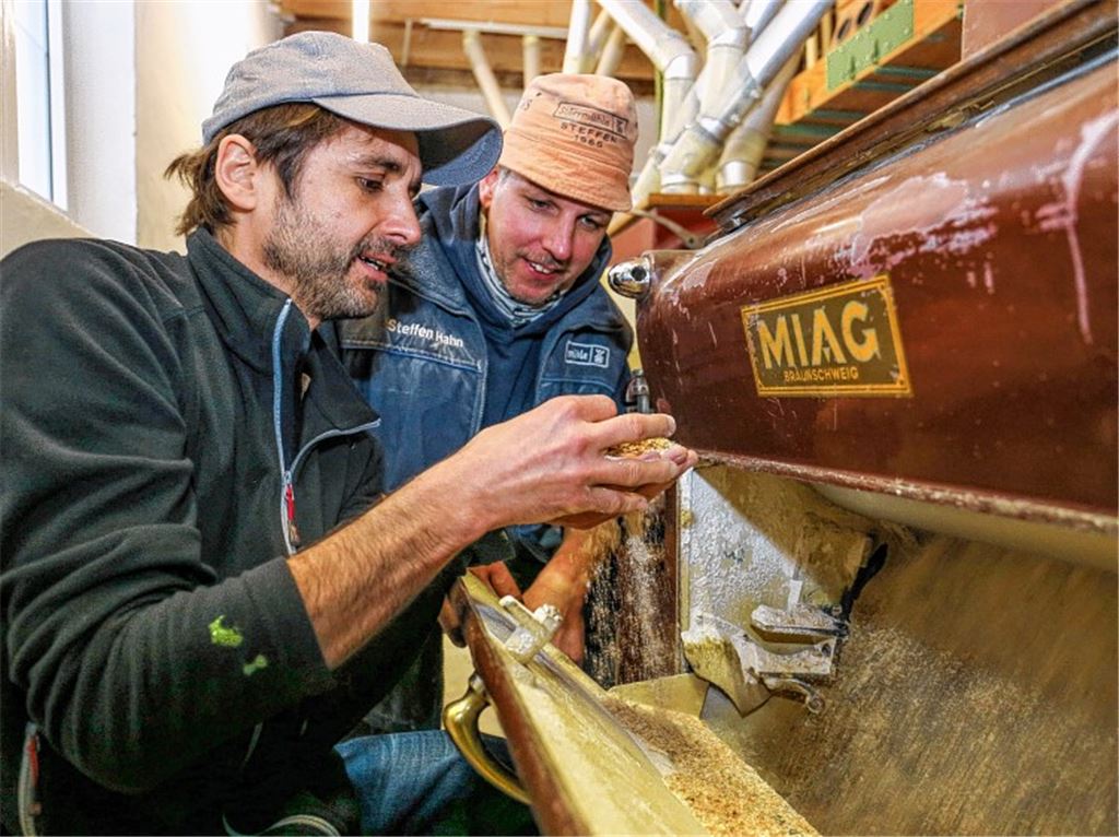 Ob beim Blick in den Walzenstuhl oder im Sacklager: Müllermeister Klaus Dobler (li.) und Steffen Hahn tragen immer Hut, sonst hätten sie am Ende des Arbeitstages graue Haare vom Staub.