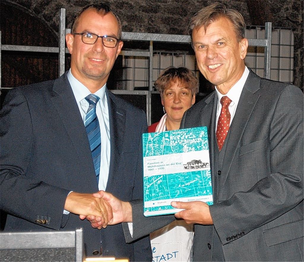 Oberbürgermeister Frank Schneider (li.) und Autor Karl Hittler präsentieren das Werk, im Hintergrund Stadtarchivarin und Mitherausgeberin Marlis Lippik. Bild rechts: Auch Straßenwart Gottlob Schnaufer, der auf der historischen Aufnahme zu sehen ist, findet sich im neuen Ortsfamilienbuch mit seinem Anhang wieder.