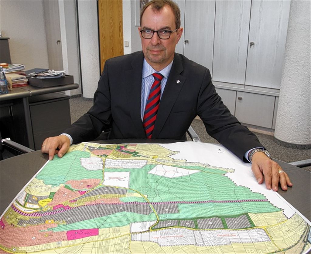 Oberbürgermeister Frank Schneider präsentiert eine Karte mit Bereichen, die für ein neues Mühlacker Gewerbegebiet im Gespräch waren oder immer noch sind. Foto: Sadler