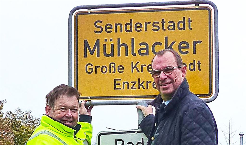 Oberbürgermeister Frank Schneider und Armin Saussele vom Bauhof am neu montierten „Senderstadt“-Schild. Foto: privat