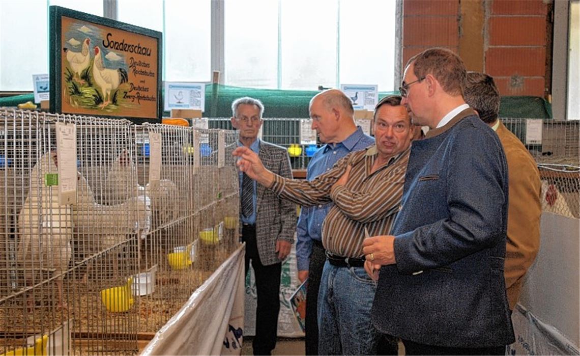 Oberbürgermeister Frank Schneider (vorn) informiert sich in der angeschlossenen Bezirkssonderschau der Deutschen Reichshühner. Foto: Appich