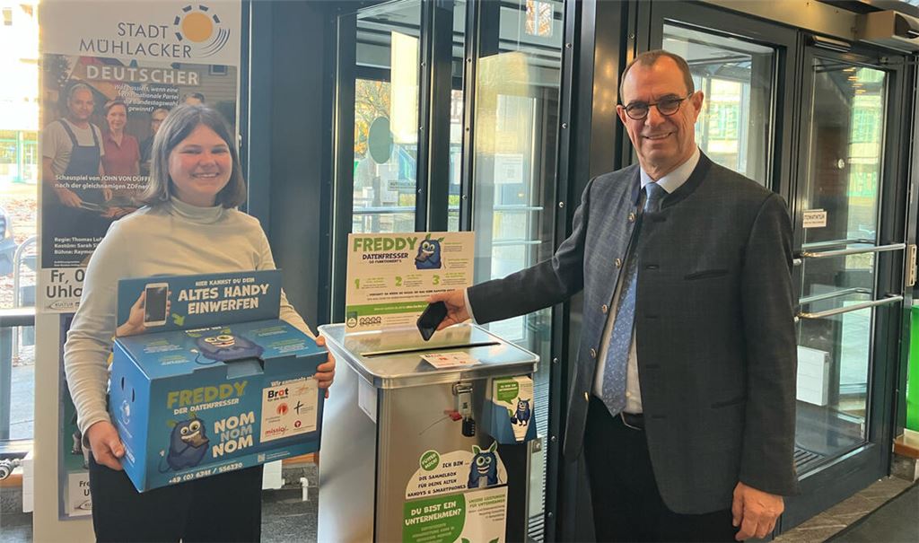 Oberbürgermeister Schneider und Klimaschutzmanagerin Johanna Wösle an der Sammelbox für ausrangierte Mobiltelefone und Tablets im Rathaus. Foto: Stadt Mühlacker