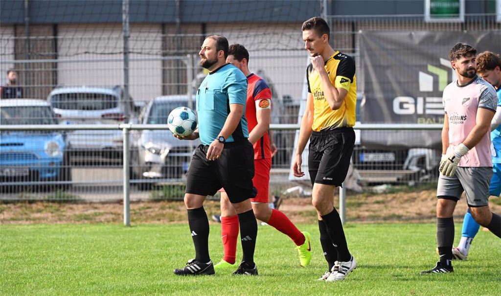 Oftmals nicht nur beim Einlauf im Mittelpunkt: der Schiedsrichter – hier Can Eryilmaz vor dem Pokalduell zwischen Lienzingen und Ötisheim. Fotos: Schüller, Rubner