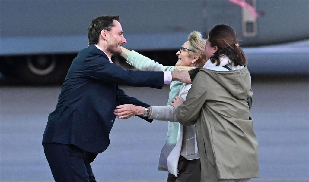 Olivier Vandecasteele (l) trifft seine Familie bei der Ankunft auf dem Militärflughafen Melsbroek.