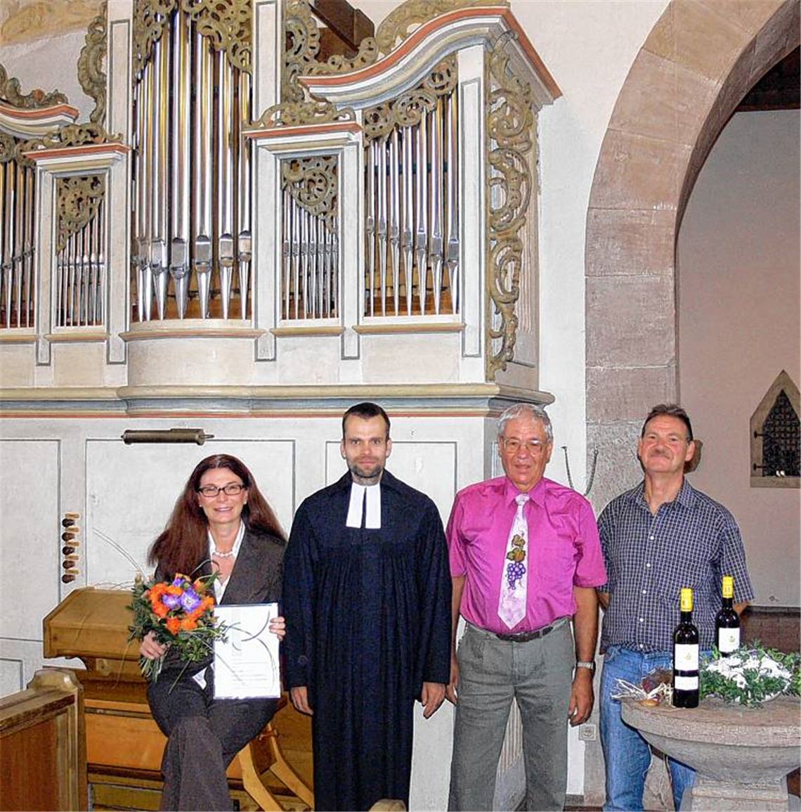 Orgelfreunde: Sabine Velte (li.) wird von Pfarrer Jan Funke (2. v. li.) für über 25-jährige Organistentätigkeit ausgezeichnet. Herbert Gläßgen und Werner Häußermann (v. re.) bekamen für ihre Hilfe bei der Orgelrenovierung Wein und gebackene Orgelpfeifen von Organistin Sabine Velte. Foto: Garhöfer