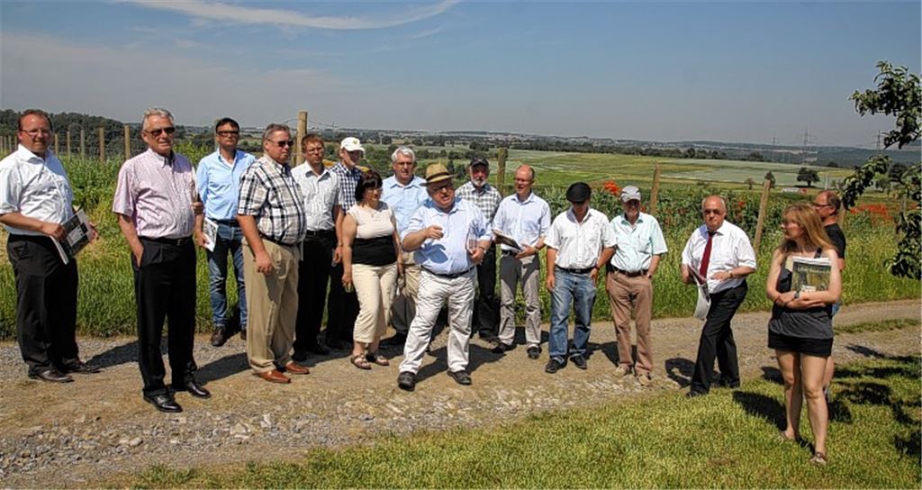 Ortstermin: Vertreter des Regionalverbands, der Behörden, der Bürgerinitiative und des Betreibers treffen sich bei schweißtreibenden Temperaturen am Rand des Steinbruchs in Enzberg, wo der ortskundige Günter Bächle (Mitte, mit Strohhut) die Vorgeschichte der aktuellen Diskussion erläutert. Schon in den 1980er Jahren habe es Proteste gegen eine Ausdehnung der Abbauflächen gegeben. Fotos: Franz