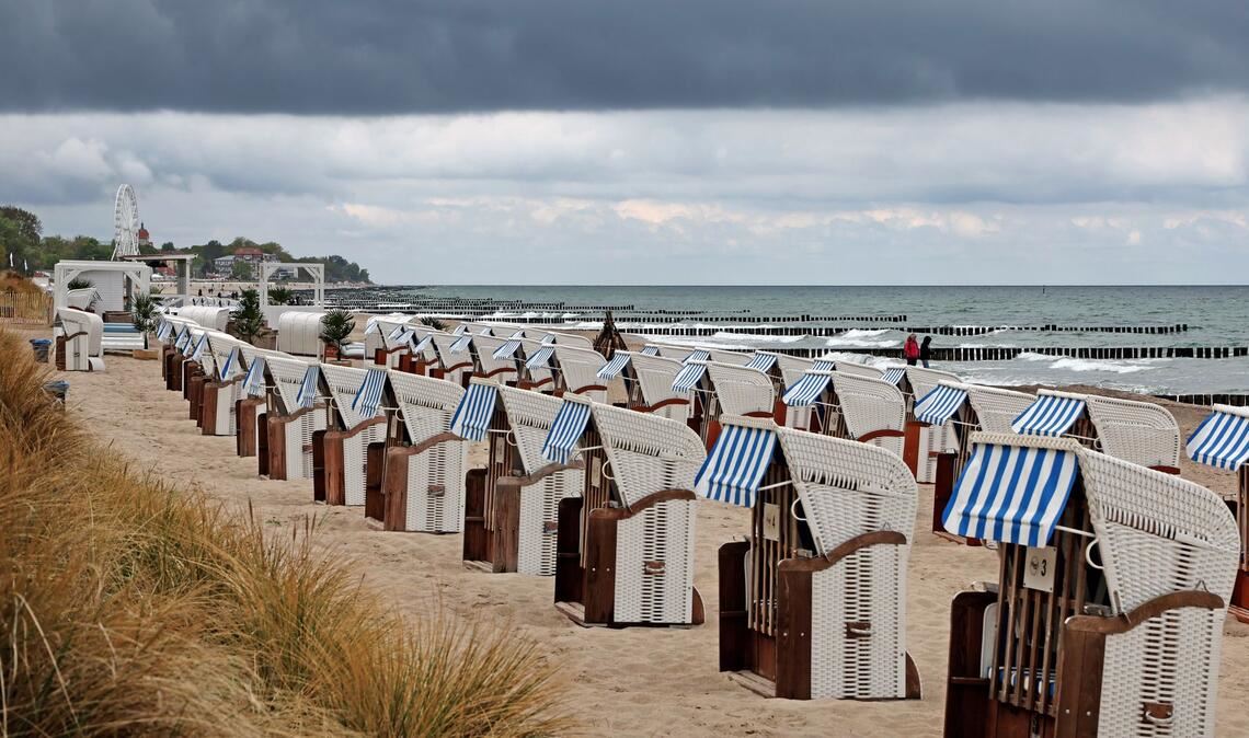 Ostsee: Strandkörbe in Wartestellung – graue Wolken ziehen auf, kaum Menschen am Wasser
