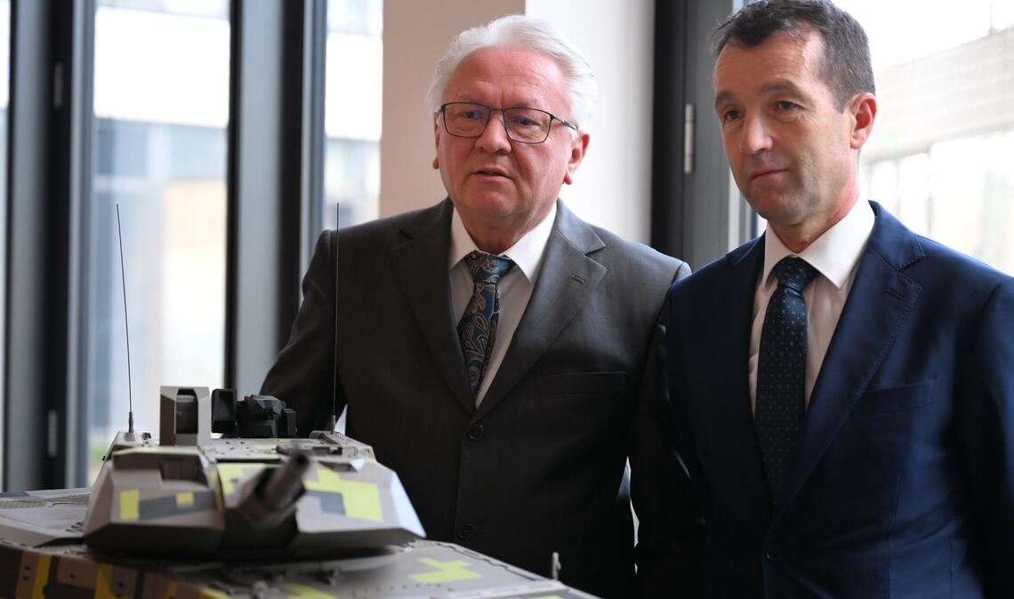 Papperger und Escribano bei einem Modell des Rheinmetall-Kampfpanzers Panther.