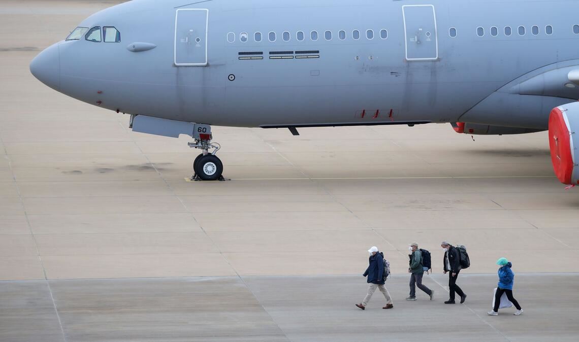 Passagiere des von einem Hantavirus-Ausbruch betroffenen Kreuzfahrtschiffs steigen am Flughafen Eindhoven aus einem Flugzeug aus.