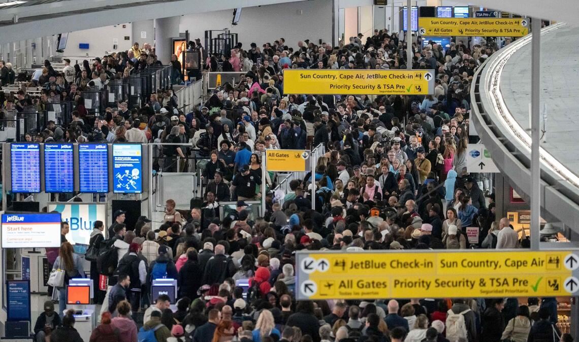 Passagiere warten in einer TSA-Schlange.