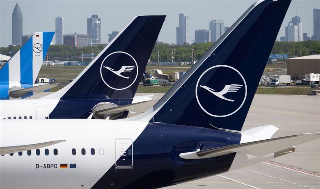Passagiermaschinen der Lufthansa und der Condor stehen am Flughafen Frankfurt, während im Hintergrund die Bankentürme von Frankfurt zu sehen sind. (Symbolbild)