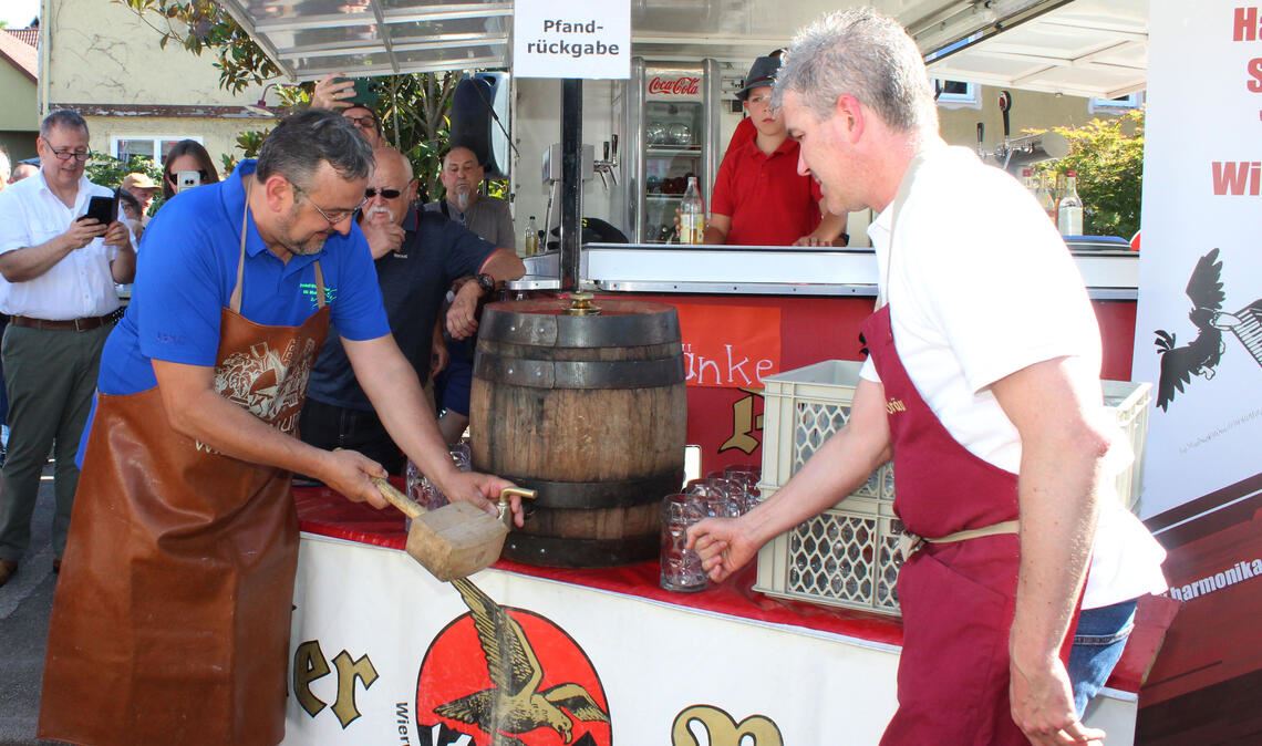 Perfekt sticht Bürgermeister Igor Bonino (li.) aus Pinasca unter den Augen seines Wiernsheimer Kollegen Matthias Enz beim Straßenfest das obligatorische Fass Bier an. Fotos: Prokoph