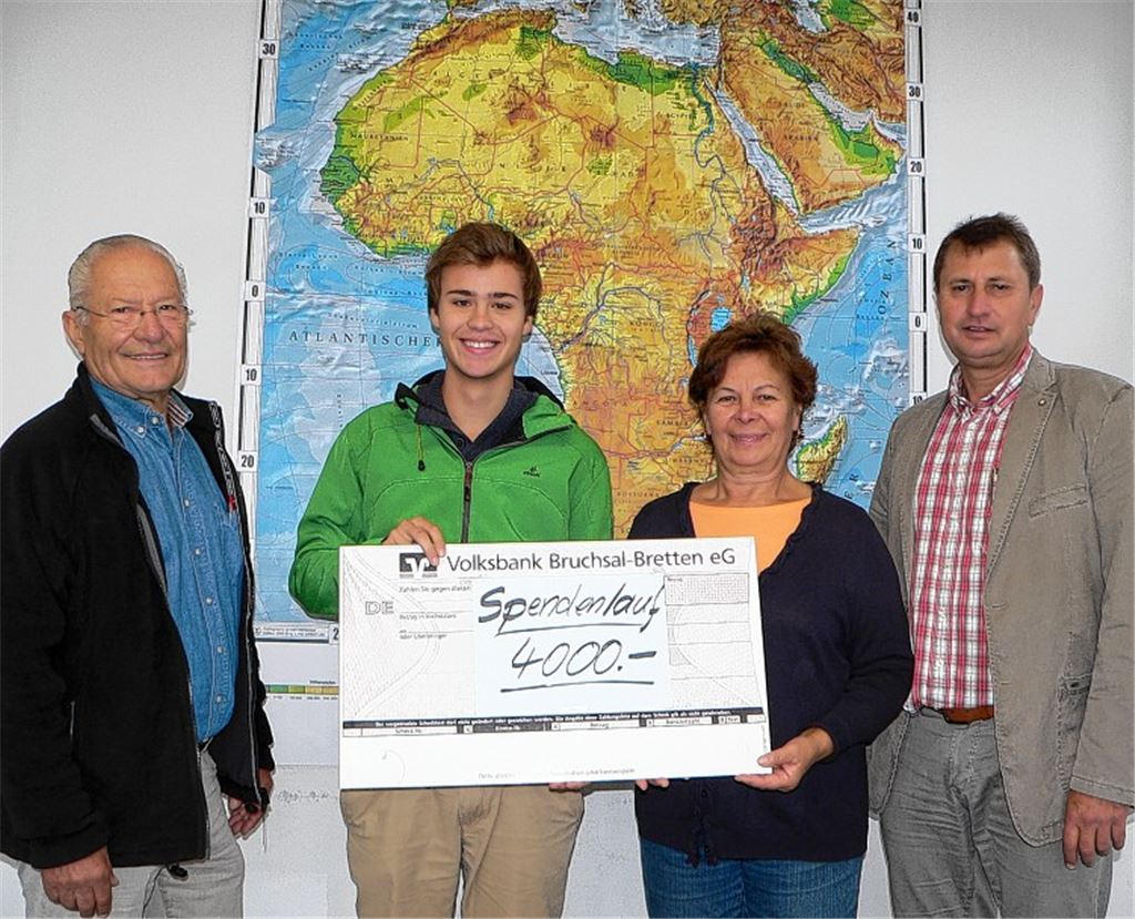 Peter Hoffmann (li.) und seine Frau Ursula vom Verein „Tansania – wir helfen“ freuen sich über eine Spende, die Schüler Friedhelm Egerer von der Afrika-AG des Salzach-Gymnasiums und Lehrer Bruno Böhler (re.) überreichen. Foto: privat