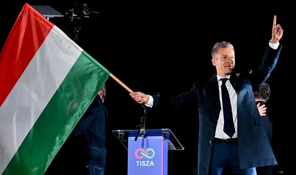 Peter Magyar, Vorsitzender der Oppositionspartei Tisza, schwenkt die ungarische Flagge nach der Bekanntgabe der Teilergebnisse der Parlamentswahl.