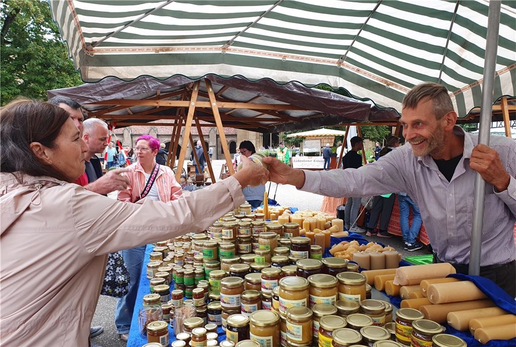 Peter Reithmeier vertreibt an seinem Stand nicht nur allerlei Honigprodukte, er macht auch auf das Bienensterben aufmerksam. Bild re.: Es ist dann doch ein bisschen mehr geworden – der Kinderwagen wird zum mobilen Einkaufskorb, und der Nachwuchs wird getragen.Fotos: Schröder