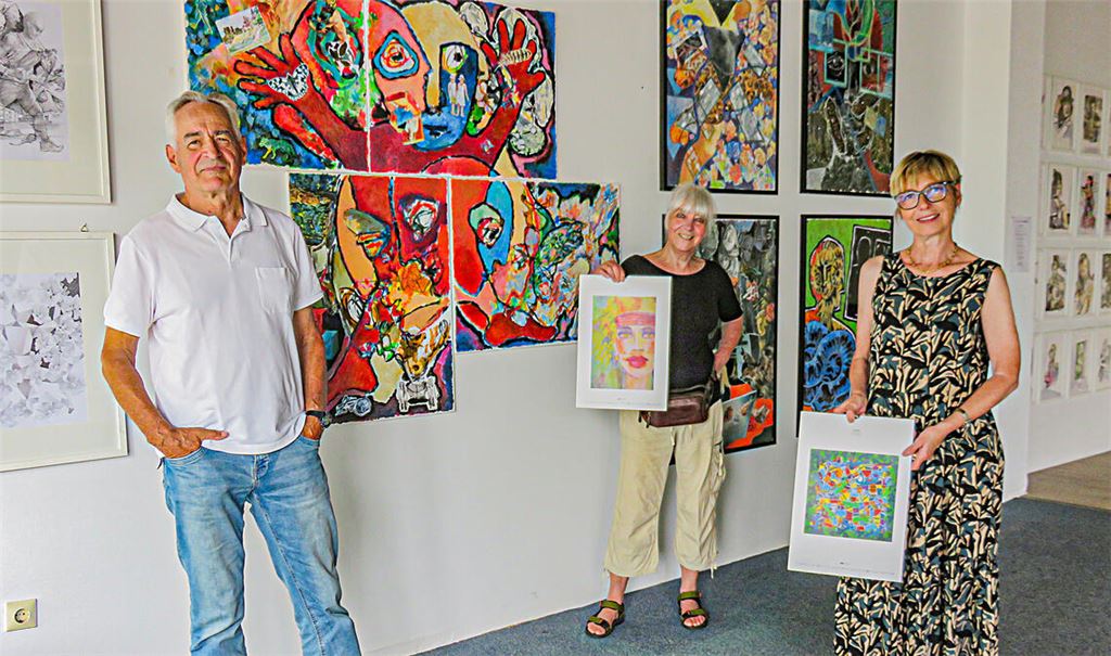 Peter Schumann, Bettina Rebhuhn und Bettina Wenz (re.) gehören zu den Kunstschaffenden, die derzeit eine Ausstellung in den ehemaligen Räumen des Malergeschäfts Geissel vorbereiten. Weitere Grafiker sind mit beteiligt, von denen auf diesem Foto Arbeiten ins Bild gehalten werden, die in einem Kalender der Gruppe abgedruckt worden sind. Foto: Becker