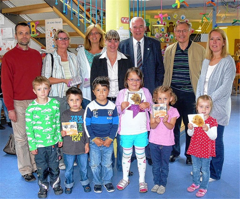 Pfarrer Jan Funke, Sabine Wagner (Kindergarten Fröbelweg), Birgit Poszlovszki-Pelz (Kindergarten Schwalbenstraße), Bürgermeisterin Sigrid Hornauer, Gerhard Hohmann und Reinhold Roller (Schwäbischer Albverein) und Brigitte Schuster (Haus für Kinder an der Kraichquelle) mit Kindergartenkindern bei der Übergabe der CDs und DVDs.